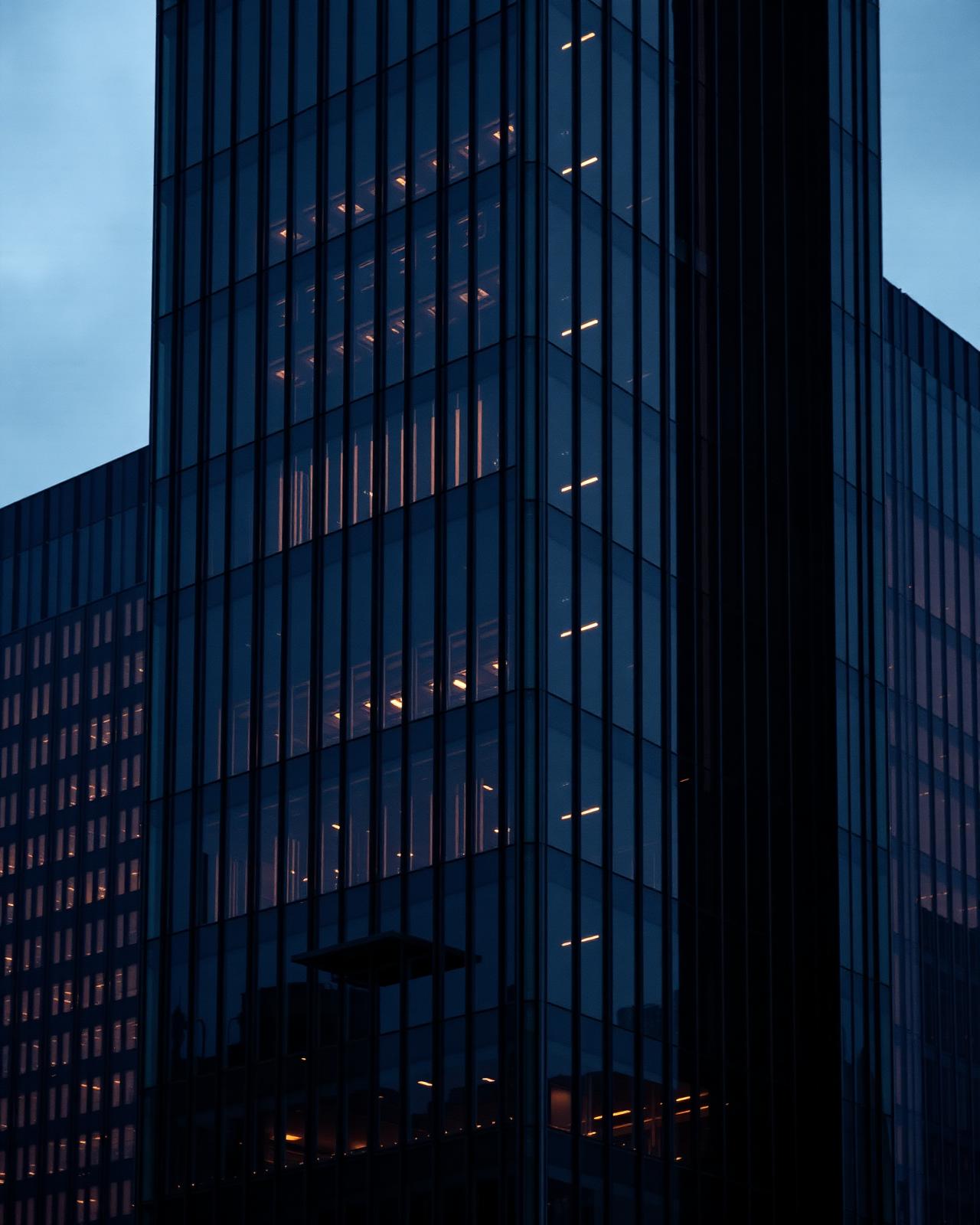 Fachada de vidro de torre corporativa ao entardecer